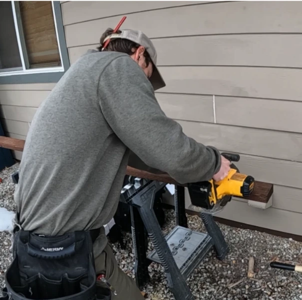 lead paint repair in Rochester NY: cutting exterior trim board on an older house